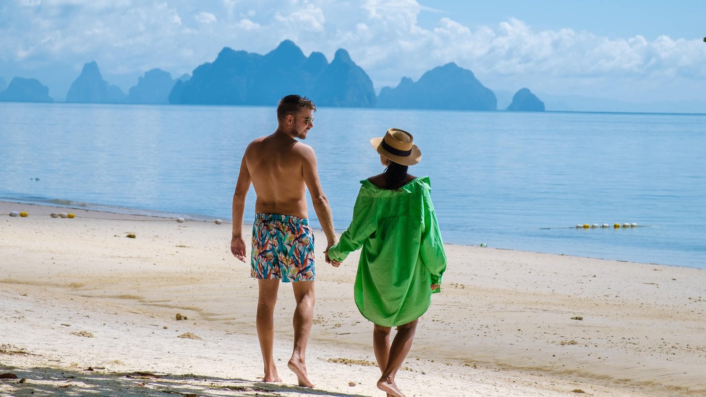 Ein Paar an einem Strand | Tipps und Tricks für den Urlaubsfli