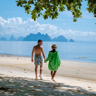 Ein Paar an einem Strand | Tipps und Tricks für den Urlaubsfli
