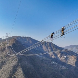 13. Januar: Diese Arbeiter in China haben einen sehr "luftigen" Arbeitsplatz. Um den Strom eines Windkraft- und Sonnenenergie-Parks aus der Tengger-Wüste in andere Regionen des Landes zu leiten, errichten diese Bauarbeiter Chinas erste Ultrahochspannungsleitung über eine Strecke von 1.600 Kilometer.