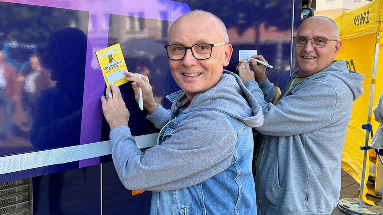 Zwei Männer stimmen am Hitparaden-Truck in Zweibrücken für ihre Lieblingssongs ab | Die Hitparaden-Truck-Tour in Bildern