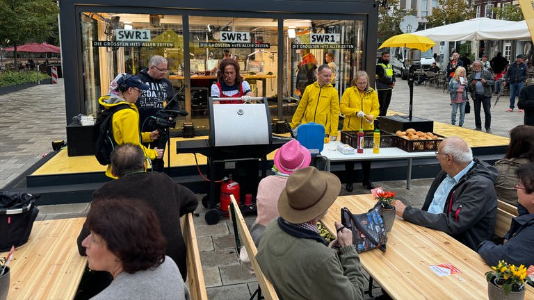 Hanns grillt im Dirndl Bratwürste