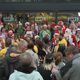 SWR1 Hitparade 2024: Stadtwette gewonnen! Mindestens 50 Menschen sollten im Weihnachtsoutfit zum Kornmarkt kommen. Zur Feier des Tages wird ein Weihnachtslied angestimmt.