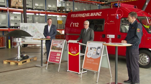 Der Mainzer Oberbürgermeister Michael Ebling, der rheinland-pfälzische Innenminister Roger Lewentz und ein Feuerwehrmann erläutern den Ablauf des Warntags.