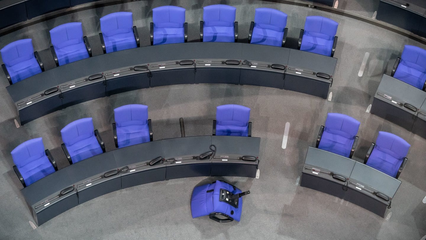 Eine Sitzreihe im Bundestag. Ein Stuhl liegt umgekippt vor der Sitzreihe. Der Bundestag hat über die Wahlrechtsreform abgestimmt.