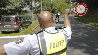 Polizeibeamter winkt Motorradfahrer zur Kontrolle