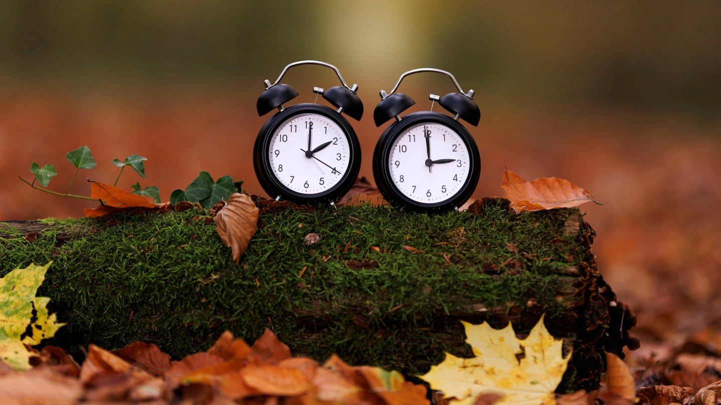 Zwei Wecker mit unterschiedlichen Uhrzeiten, Symbolbild Zeitumstellung auf Winterzeit