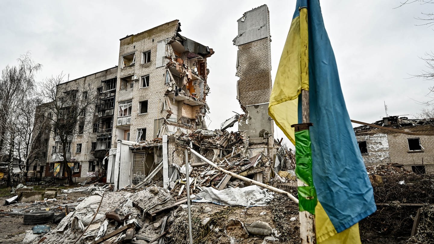 Eine ukrainische Flagge steht vor einem zerstörten Wohnhaus in Orikhiv, im Südosten der Ukraine. (Januar 2024)