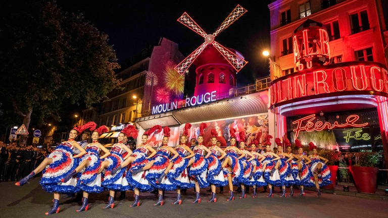 8. Juli: Die Windmühle des Moulin Rouge hat ihre Flügel wieder! Im April waren die Flügel nachts abgebrochen und auf den Fußweg vor dem Pariser Varieté Theater gefallen. Jetzt wurden die neuen Flügel feierlich eingeweiht. Dabei durften natürlich nicht die Tänzerinnen fehlen, die in bunten Röcken vor dem Gebäude den französischen Cancan zum Besten gaben.