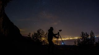 Ein Mann fotografiert den Nachthimmel | Tipps: So lassen sich Sternschnuppen am besten fotografieren