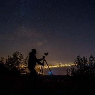 Ein Mann fotografiert den Nachthimmel | Tipps: So lassen sich Sternschnuppen am besten fotografieren