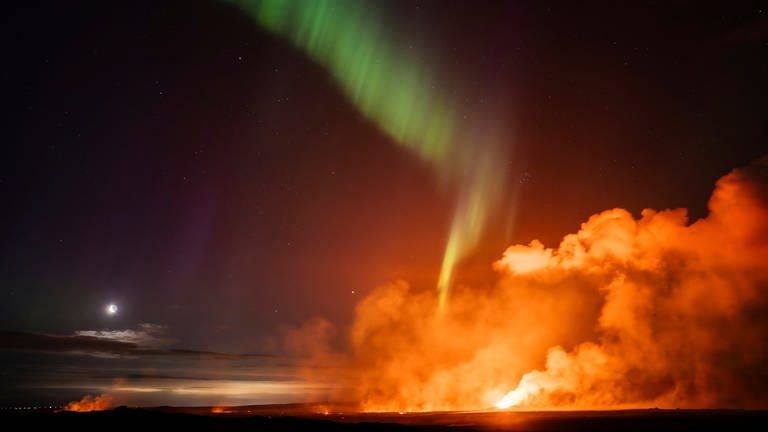 30. August: Vulkanausbruch auf Island: Nordlichter erscheinen über einer Eruptionsstelle und dem Mond im Hintergrund auf der Halbinsel Reykjanes. Für Isländerinnen und Isländer ist das längst nichts Besonderes mehr. Das war der sechste Ausbruch in den letzten neun Monaten. 