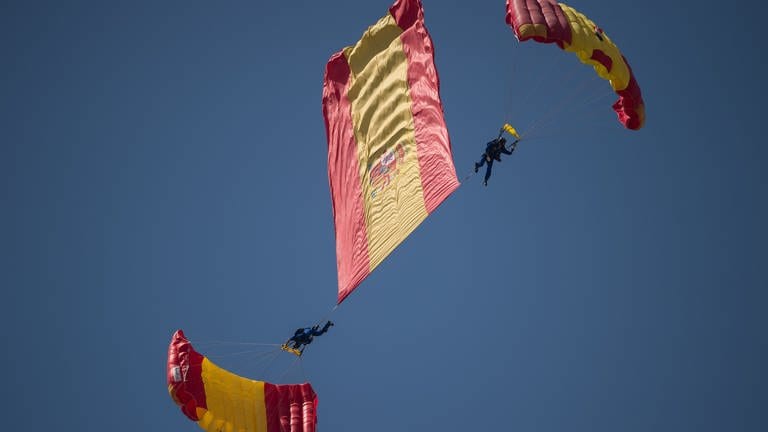 9. September: Keine Sorge, hier sind Profis am Werk. Was auf den ersten Blick nach einer verhedderten Lage aussieht, ist Teil der Flugshow "International Torre del Mar Airshow 2024" in Spanien. Neben militärischen Flugzeugen wie dem Eurofighter Jet waren am Wochenende auch zwei Mitglieder der Papea, der akrobatischen Fallschirmjägerpatrouille der spanischen Luftwaffe beteiligt. Sie wirbelten nicht nur sich selbst, sondern auch eine riesige spanische Flagge durch die Luft.