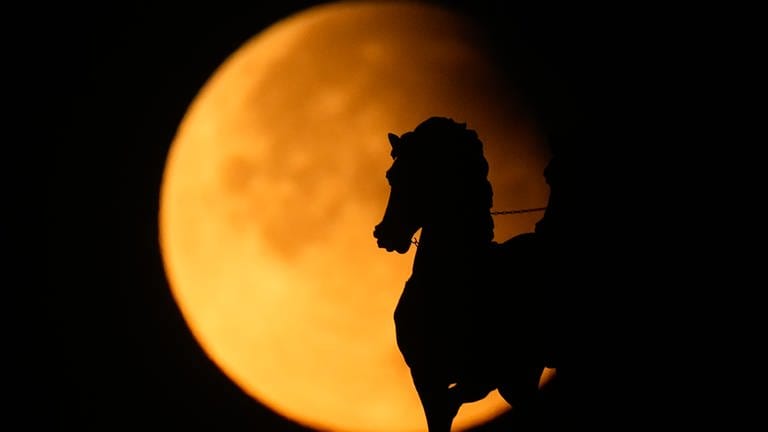 18. September: Eine partielle Mondfinsternis hat am frühen Morgen viele Frühaufsteher begeistert. Der Vollmond war teilweise von der Erde verdeckt zu sehen, wie hier in Moskau. Der "Supermond" – samt "angeknabberter Ecke" – erhebt sich hinter einer Pferdestatue auf dem Triumphbogen am Moskauer Siegesplatz. Durch seine relativ große Nähe zur Erde wirkt der Mond dabei besonders groß. Bei uns konnte man die partielle Mondfinsternis am besten in den frühen Morgenstunden um 4.44 Uhr sehen.