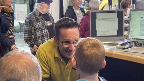 Christian Balser im Gläsernen Studio im Gespräch mit einem jungen Hörer.