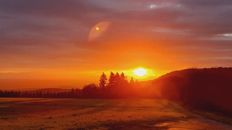 Sandra König aus Weibern schreibt uns zu ihrem Bild "Sonnenaufgang in der Vulkaneifel": "Ich war auf dem Weg zur Arbeit und ganz plötzlich war die gesamte Landschaft in ein zauberhaftes glühendes rotes Licht getaucht. Ich musste unbedingt bei der ersten Gelegenheit anhalten, um diese faszinierende Lichtstimmung festzuhalten,  die mir einen wundervollen Start in den Tag geschenkt hat."