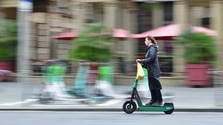 Eine Frau fährt mit einen E-Scooter | Welche Verkehrsregeln gelten für E-Scooter?