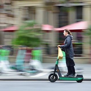 Eine Frau fährt mit einen E-Scooter | Welche Verkehrsregeln gelten für E-Scooter?