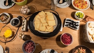 Raclettekäse und Schalen mit Zutaten | Das kommt ins Pfännchen | Tipps für ein gelungenes Raclette zu Silvester