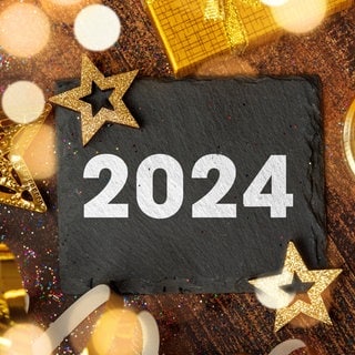 2024 steht auf einer Schiefertafel mit goldenen Dekorationen | Die SWR1 Highlights 2024