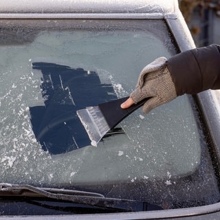 Eiskratzen an einer Frontscheibe | Autoscheibe von Eis befreien – ohne Eiskratzer