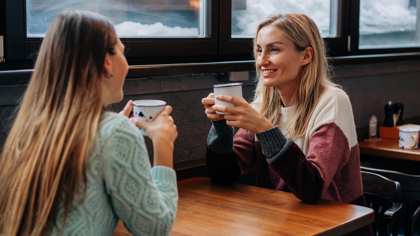 Zwei Frauen trinken in einem Café zusammen Kaffee | Einsamkeit und wie Apps dagegen helfen können