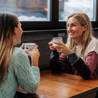 Zwei Frauen trinken in einem Café zusammen Kaffee | Einsamkeit und wie Apps dagegen helfen können