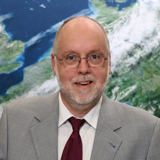 Prof. Roland Potthast, beim Deutschen Wetterdienst, steht vor einer Wetterkarte. Er arbeitet für den Deutschen Wetterdienst. In SWR1 Leute erklärt er, wie das Wetter vorhergesagt wird und welche Chancen er für die Wetterprognose mit KI sieht.