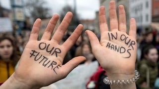 Eine Schülerin zeigt während der Demo «Fridays for Future» in HalleSaale ihre Hände mit der Aufschrift «Our future in our hands».