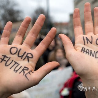 Eine Schülerin zeigt während der Demo «Fridays for Future» in HalleSaale ihre Hände mit der Aufschrift «Our future in our hands».