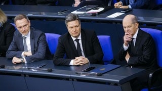 Christian Lindner, Robert Habeck und Olaf Scholz sitzen nebeneinander im Bundestag. Symbolbild für das Ende der Ampelkoalition