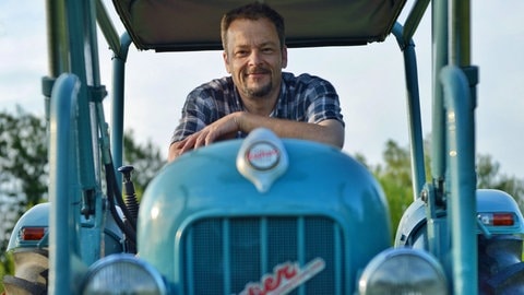 Naturfilmer und -schützer Jan Haft sitzt auf einem blauen Traktor.