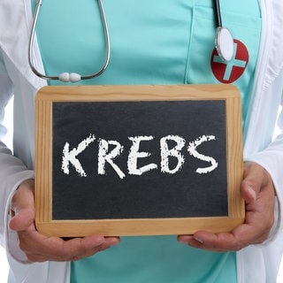 Ein Arzt hält eine Tafel mit der Aufschrift "Krebs".  Petra Voiß ist zu Gast bei SWR1 Leute. Sie ist Direktorin der bundesweit ersten Klinik für Integrative Onkologie und Supportivmedizin in Essen. Dort werden Naturheilkunde und Schulmedizin kombiniert. Ziel: mit der Mind-Body-Medizin Selbstheilungskräfte fördern und bei der Krankheitsbewältigung unterstützen.