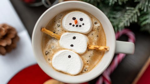 Ein Schneemann aus Marshmallows ziert eine heiße Schokolade
