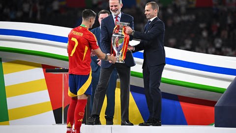 Fußballer Alvaro Morata (l-r) bekommt nach dem EM-Sieg die Trophäe von König Felipe von Spanien und vom UEFA-Präsident Aleksander Ceferin überreicht.