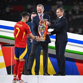 Fußballer Alvaro Morata (l-r) bekommt nach dem EM-Sieg die Trophäe von König Felipe von Spanien und vom UEFA-Präsident Aleksander Ceferin überreicht.