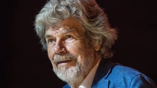 Reinhold Messner: Porträtaufnahme des berühmten Bergsteigers vor schwarzem Hintergrund