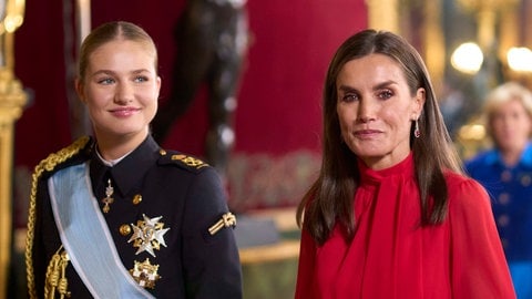 Königin Letizia von Spanien trägt ihr dunkles Haar offen und ein schickes rotes Kleid. Neben ihr läuft ihre Tochter in Militäruniform und streng zurückgebundenem Zopf, denn die Thronfolgerin Leonor von Spanien macht derzeit eine Ausbildung beim Spanischen Militär.