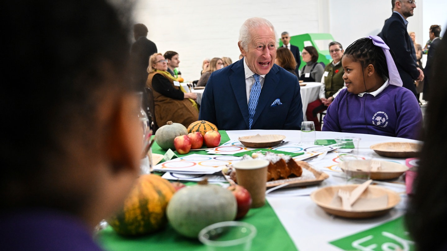 Charles sitzt an einem Esstisch mit Kindern: An seinem Geburtstag besuchte der britische König die Grundschule Rye Oak in London, die am Coronation Food Project teilnimmt.