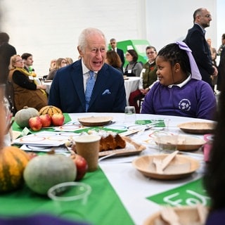 Charles sitzt an einem Esstisch mit Kindern: An seinem Geburtstag besuchte der britische König die Grundschule Rye Oak in London, die am Coronation Food Project teilnimmt.