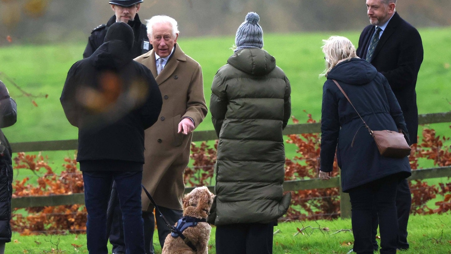 König Charles III. spricht nach dem Kirchgang am Sonntag mit Passanten über deren Hund.