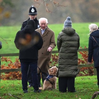 König Charles III. spricht nach dem Kirchgang am Sonntag mit Passanten über deren Hund.