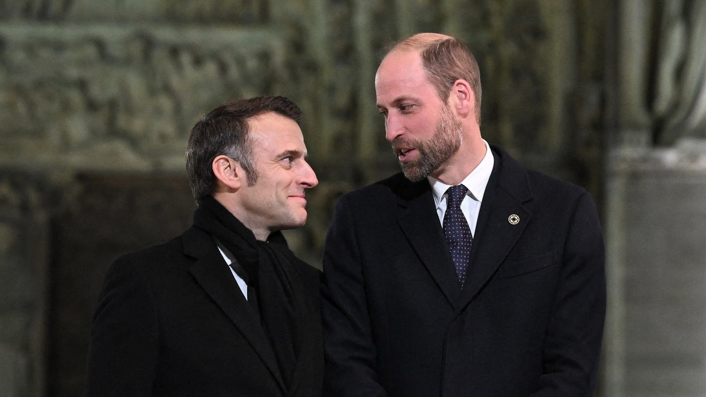 Print William (Mitte) scherzt mit dem französischen Präsidenten Emmanuel Macron und dessen Frau Brigitte vor dem Portal der frisch sanierten Kathedrale Notre Dame in Paris.