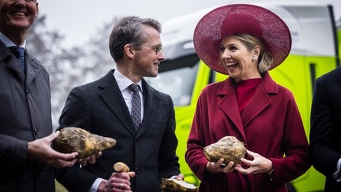 Königin Máxima hält lachend eine Zuckerrübe in den Händen