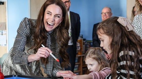 Prinzessin Kate und Kinder lachen und malen zusammen in einem Hospiz.