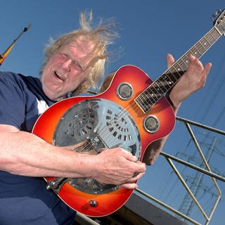 Der Country- und Schlagersänger Gunter Gabriel ("Hey Boss, ich brauch mehr Geld") spielt 2017 in Hamburg im Hafen vor seinem Hausboot Gitarre.
