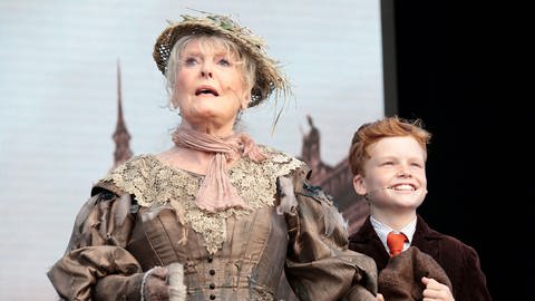  London, England, UK: West End Theater 2021, Trafalgar Square: Die weltweit durch ihren Hit "Downtown" bekannt gewordene Petula Clark als Vogelfrau im "Mary Poppins"-Musical mit kleinem rothaarigen Jungen.