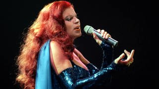 Die rothaarige Sängerin und Schauspielerin Milva (bekannt für Lieder wie "Hurra, wir leben noch") singt mit geschlossenen Augen ins Mikrofon.