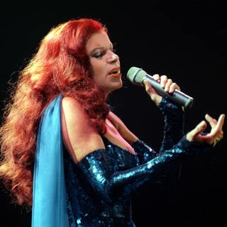 Die rothaarige Sängerin und Schauspielerin Milva (bekannt für Lieder wie "Hurra, wir leben noch") singt mit geschlossenen Augen ins Mikrofon.