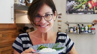 SWR4 Moderatorin Corinne Schied in der Küche mit einem Teller quark und gurken und dill, lächelnd