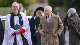 König Charles geht mit dem Pfarrer der Kirche von Flitcham zum Gottesdienst. 